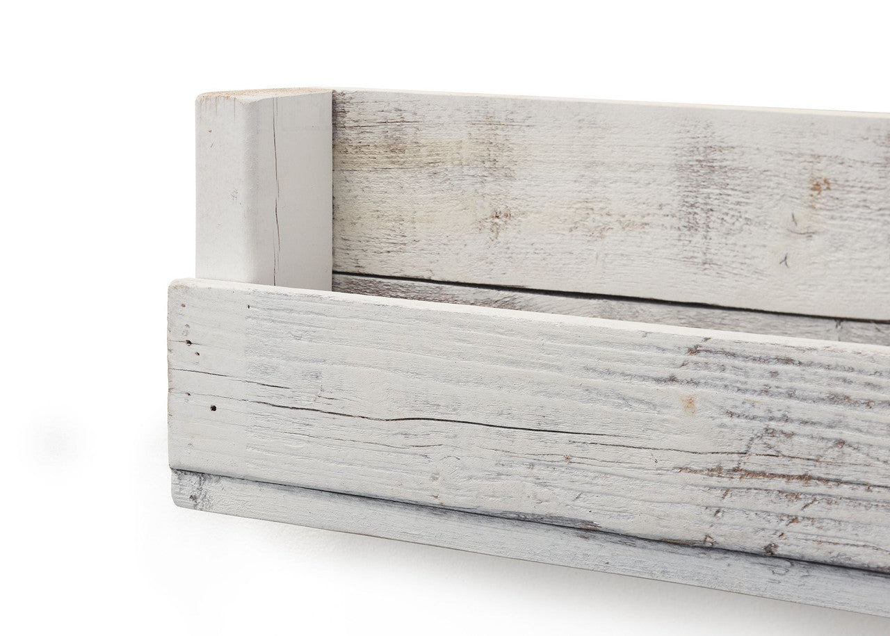 Close-up angled shot of a white, rustic wooden shelf, showcasing its handcrafted design and weathered texture. The image focuses on the shelf's corner and side, highlighting the light wood grain and subtle imperfections of the reclaimed material.