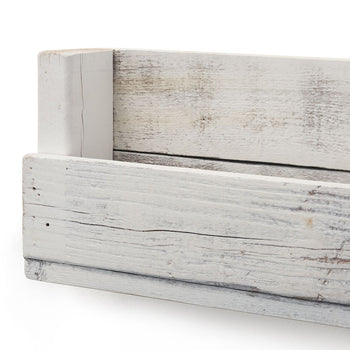 Close-up angled shot of a white, rustic wooden shelf, showcasing its handcrafted design and weathered texture. The image focuses on the shelf's corner and side, highlighting the light wood grain and subtle imperfections of the reclaimed material.