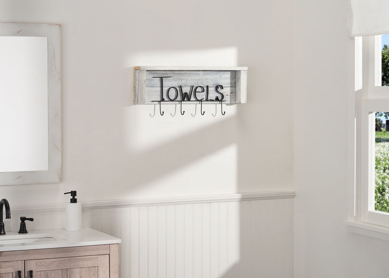 A Towel Rack with Hooks and Shelf mounted on a white wall. The rack has a shelf on top and hooks below, with the word "Towels" written on it.