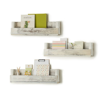 Three reclaimed wood shelves are mounted on a white wall in a staggered arrangement. Each shelf holds books and decorative items, showcasing their functionality as children's bookcases or display shelves.