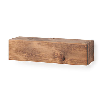 A rectangular, floating wooden shelf with a natural grain and warm brown finish is mounted against a plain white wall. The shelf is shown completely empty, highlighting its smooth top surface, organic wood knots, and clean block design.