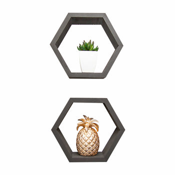 Two black hexagonal wall shelves are mounted on a white background. The top shelf holds a small green succulent in a white pot, while the bottom shelf features a decorative gold pineapple ornament.