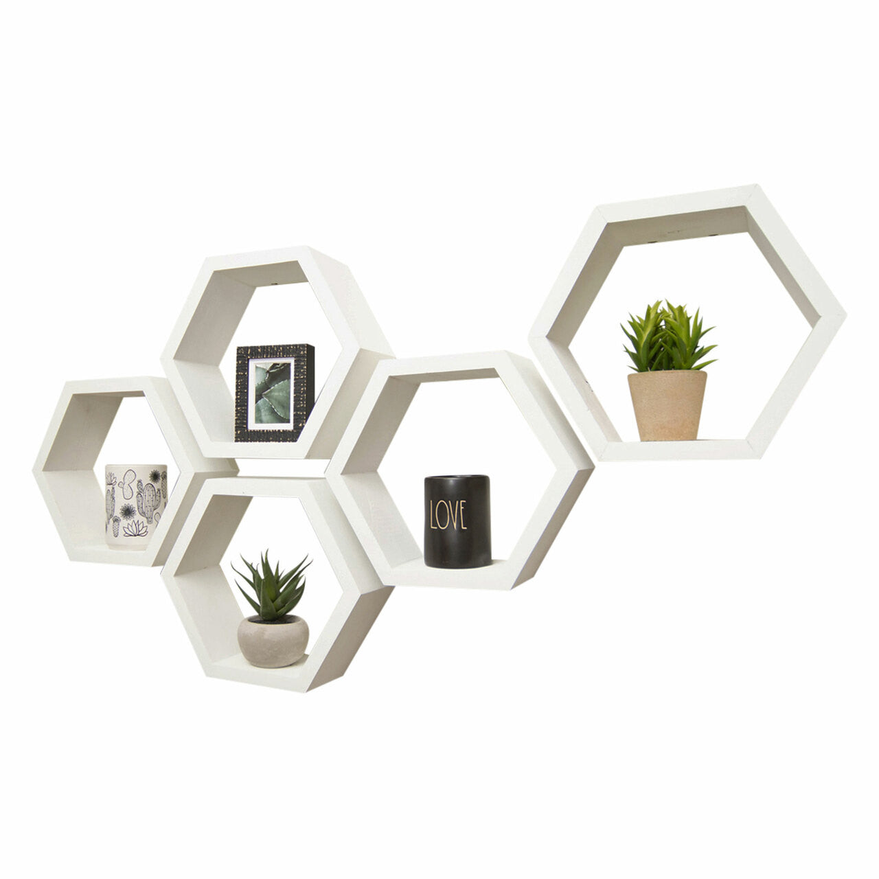 Five white hexagon shelves are creatively arranged in a staggered formation on a white wall. The shelves contain light decorative objects, creating a minimalist and modern aesthetic.