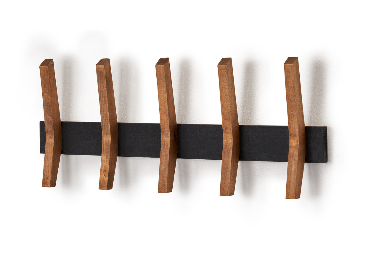 A horizontal black rectangular rack is mounted on a white wall, featuring five evenly spaced wooden pegs that jut out diagonally. The pegs have a flat, angled design, suggesting a mid-century modern aesthetic.