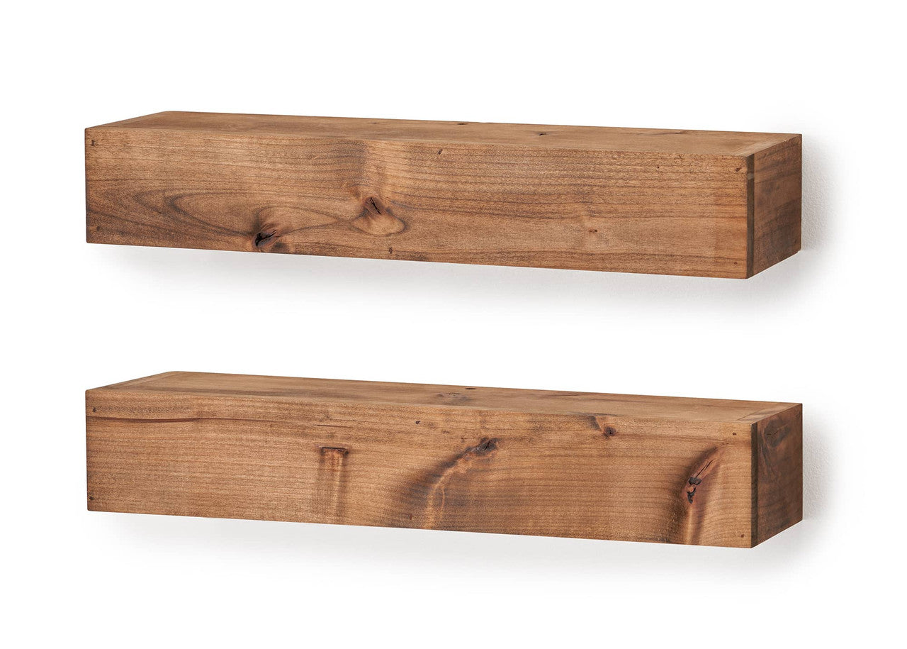 Two rustic, floating shelves made from light-brown wood are mounted on a white wall, shown in a straight-on, symmetrical view. The shelves are rectangular prisms with a natural wood grain and a slightly varying depth.