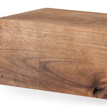 Close-up shot of a walnut wood floating shelf, showing the grain and joinery. The shelf is rectangular with a simple, clean design, featuring a rich, warm wood tone.