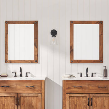 Two matching farmhouse-style vanity mirrors with wooden frames and clavos are mounted above double sinks in a bathroom setting. The mirrors reflect the white walls and enhance the room's rustic charm.