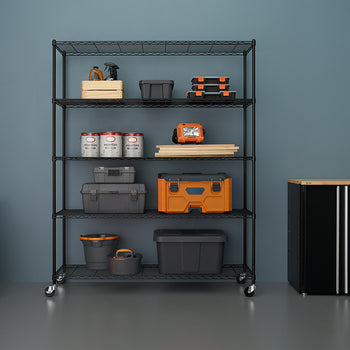 A tall, five-shelf black wire shelving unit with casters is stocked with various storage bins, toolboxes, paint cans, and other garage or workshop supplies against a blue wall. To the left is an orange and black shop vacuum, and to the right is a black storage cabinet with a wood top.