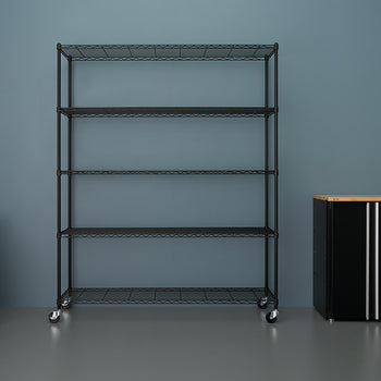 A black, five-tier wire shelving unit on casters stands against a solid blue-gray wall in a garage or workshop. To the left is an orange and black wet/dry shop vacuum, and to the right is a black storage cabinet with a wood-look top.