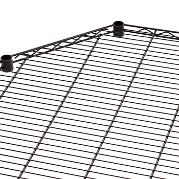 A close-up view of a black wire shelving unit's corner piece. The shelf has a pentagonal shape where two sides meet to form a corner, and it includes two cylindrical posts for vertical support.