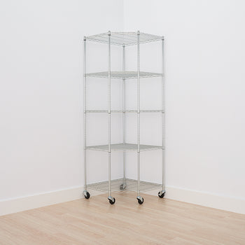 A five-tier, chrome wire shelving unit with a corner design stands on a light wooden floor, positioned against two white walls. The unit includes caster wheels for easy mobility and maximizes storage space in the corner of a room.