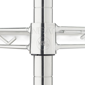 A close-up photograph focuses on a chrome wire shelving unit's central joint, where a shelf meets a vertical post. The joint collar is embossed with the brand name 