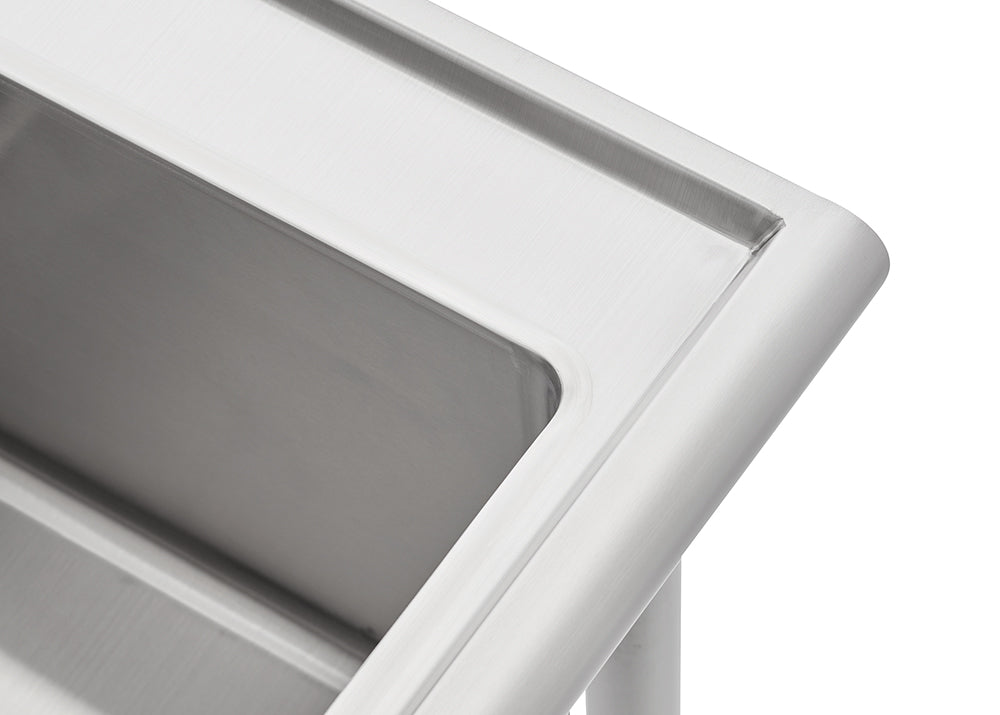 A close-up photograph shows the corner of a stainless steel sink or basin. The image highlights the smooth, brushed finish, rounded edges, and the top lip of the fixture.