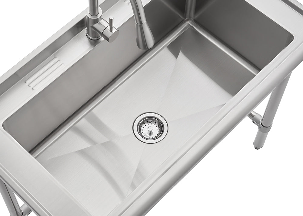 A stainless steel utility sink with a single large basin is shown from a high angle. The sink features a modern pull-down faucet on the back ledge, which also has a grooved section, and is mounted on metal legs.