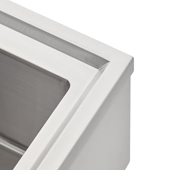 A close-up photograph shows the corner of a stainless steel sink or drop-in cooler, highlighting the brushed metal finish on the inner basin and the smooth rim. The design features a recessed channel or ledge just inside the top edge.
