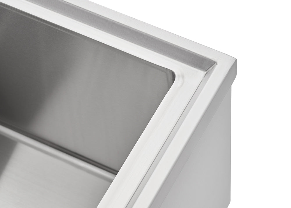 A close-up shot shows the corner of a stainless steel sink basin. The image focuses on the clean, brushed metal finish and the precise, angular edge of the sink's rim.