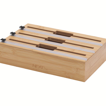 A three-tier bamboo organizer is shown with individual slots engraved for foil, paper, and plastic wrap. Each section features a clear sliding track with a black cutter for easy and precise dispensing.