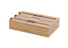 This bamboo kitchen organizer features three labeled slots for foil, wax paper, and plastic wrap, each equipped with a built-in sliding cutter. The sleek, wooden dispenser is branded with the "NEATI" logo and designed to neatly store and slice household rolls.