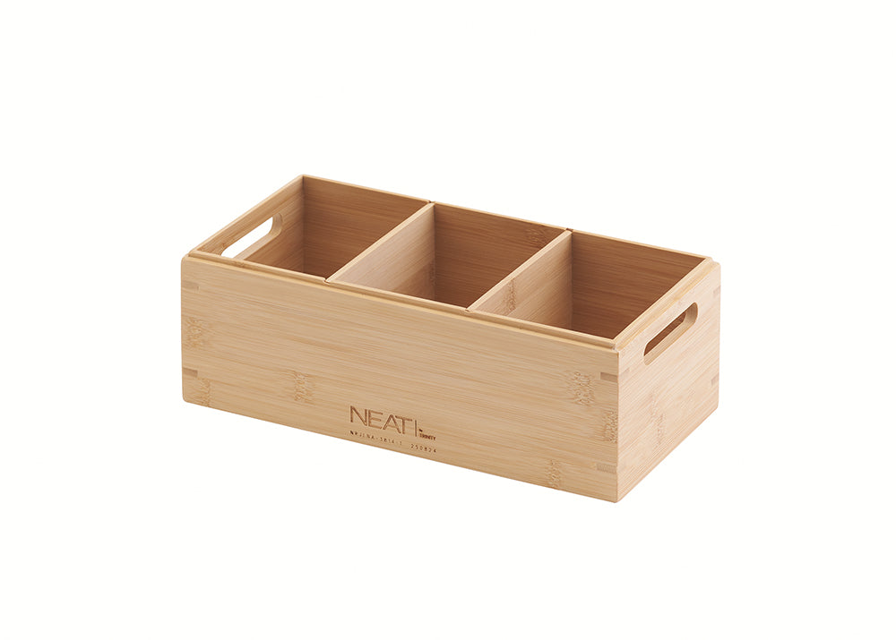 A three-compartment bamboo organizer box with open top is shown in a three-quarter view. It features an engraved 'NEAT' logo on the front panel and two cut-out handles on the sides for easy transport.