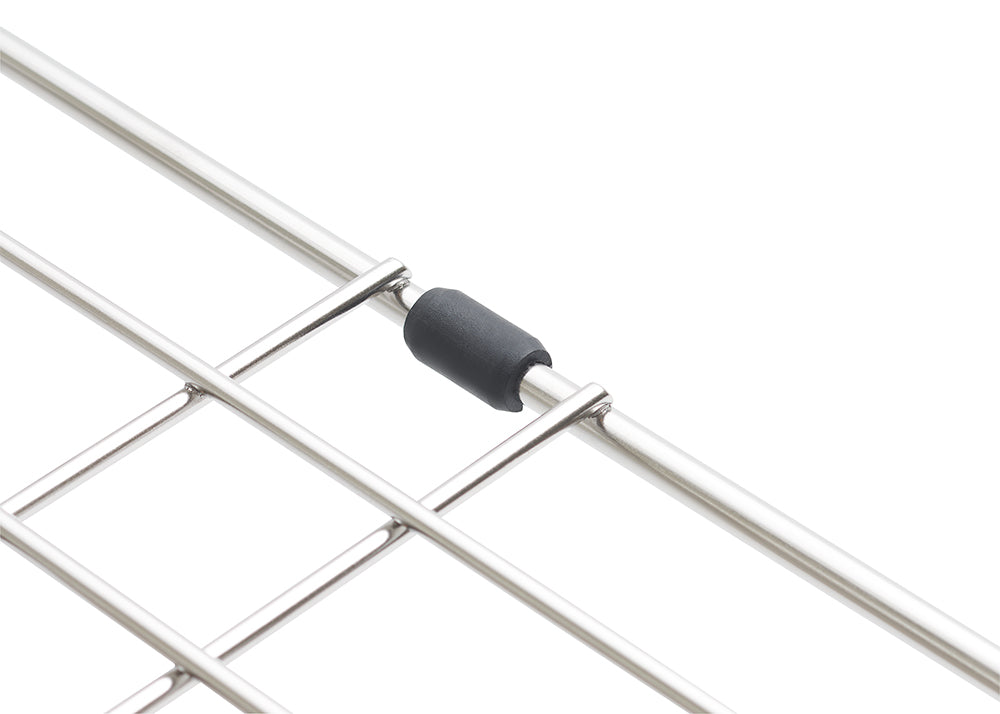 A close-up photograph displays the edge of a stainless steel wire grid, resting on a white surface. It features a small, black cylindrical rubber bumper attached where two wires cross to protect surfaces from scratches.