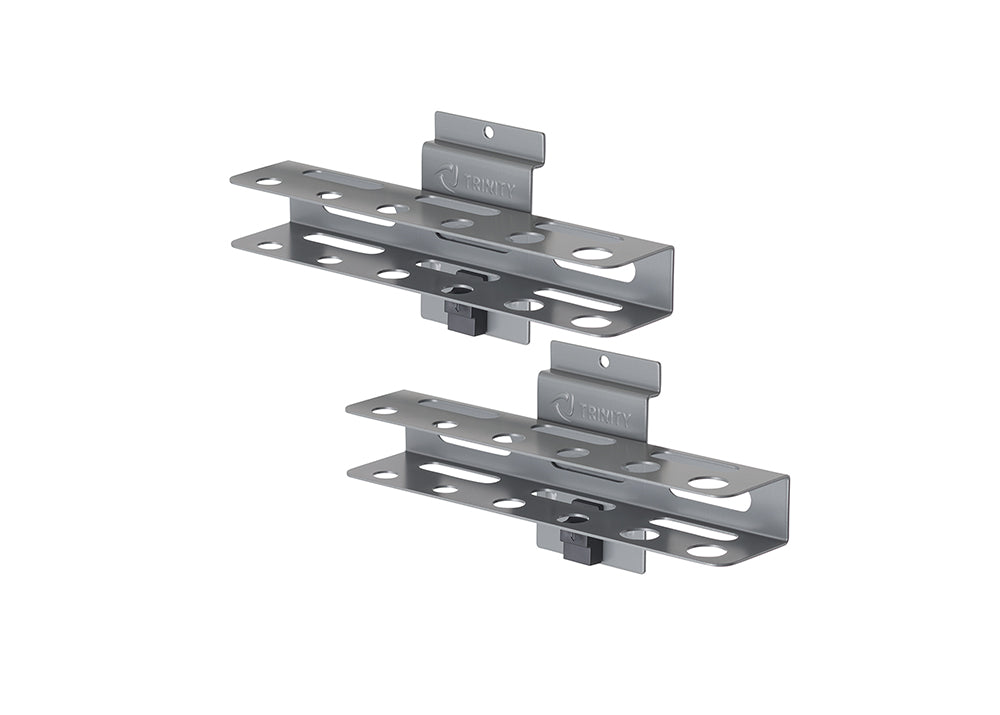 A set of two identical, brushed metal tool organizers by TRINITY are shown, designed to hold various hand tools. Each organizer features two parallel, horizontal shelves with multiple circular and oval cutouts for tool insertion, and a central mounting bracket for attachment to a wall or surface.