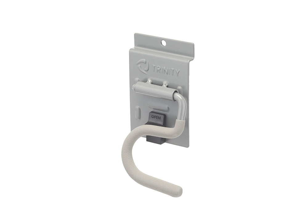 A light gray metal garage storage hook features a curved, padded arm designed for hanging tools and equipment. It is attached to a matching metallic backplate stamped with the "TRINITY" logo and equipped with a dark gray "OPEN" release latch.