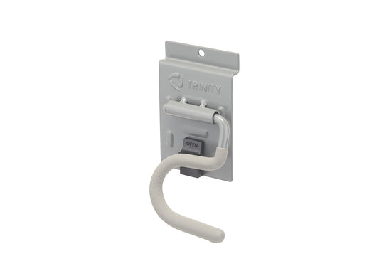 A light gray metal garage storage hook features a curved, padded arm designed for hanging tools and equipment. It is attached to a matching metallic backplate stamped with the "TRINITY" logo and equipped with a dark gray "OPEN" release latch.