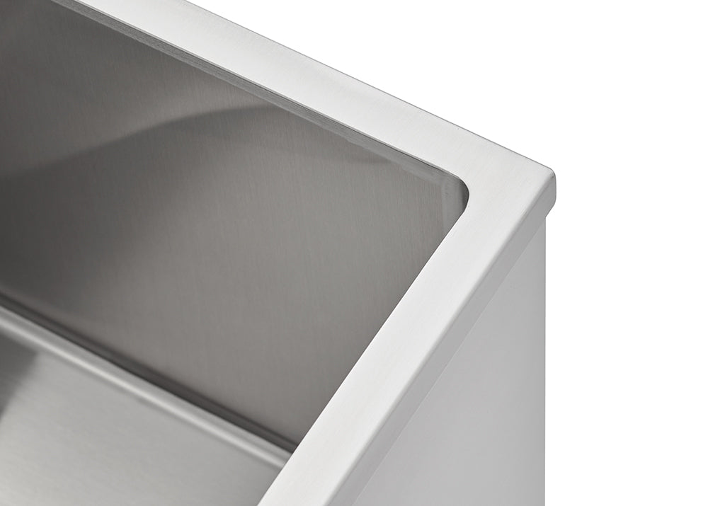 A close-up shot focuses on the clean, sharp corner and rim of a rectangular stainless steel sink basin, emphasizing its brushed metal texture. The image highlights the precise edge where the sink's rim meets the interior wall.