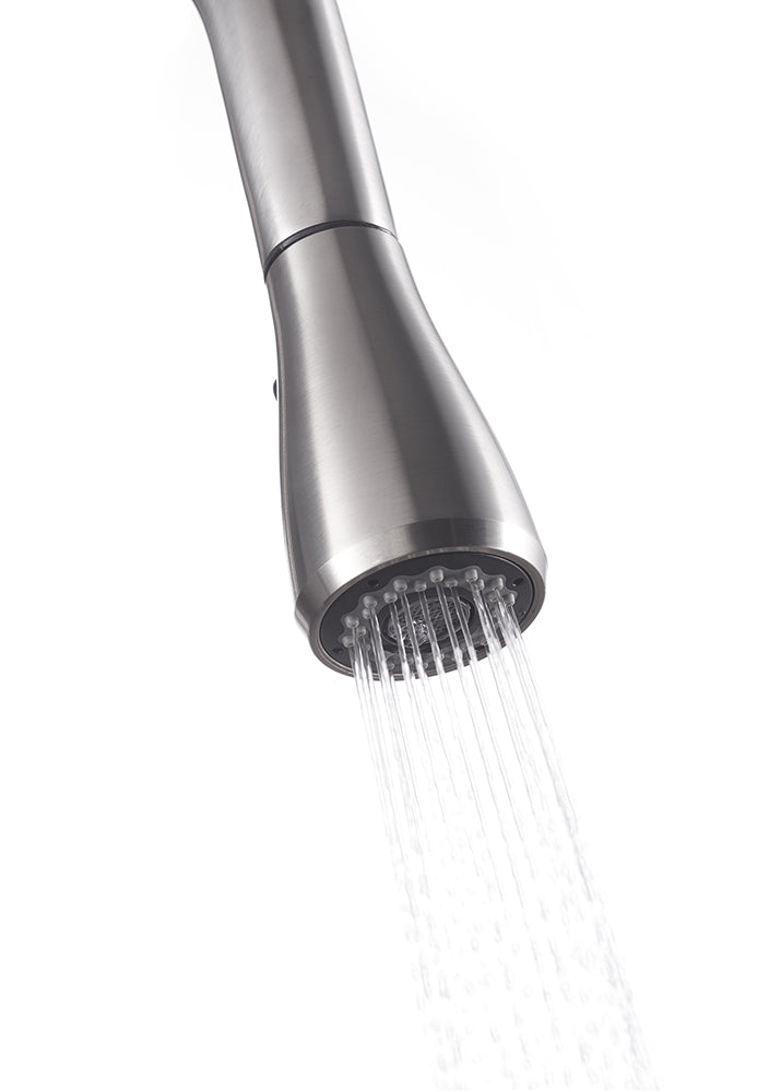 A close-up shot shows the spray head of a modern, stainless steel kitchen faucet with a brushed finish. Water streams down from the nozzle in a concentrated spray pattern against a white background.