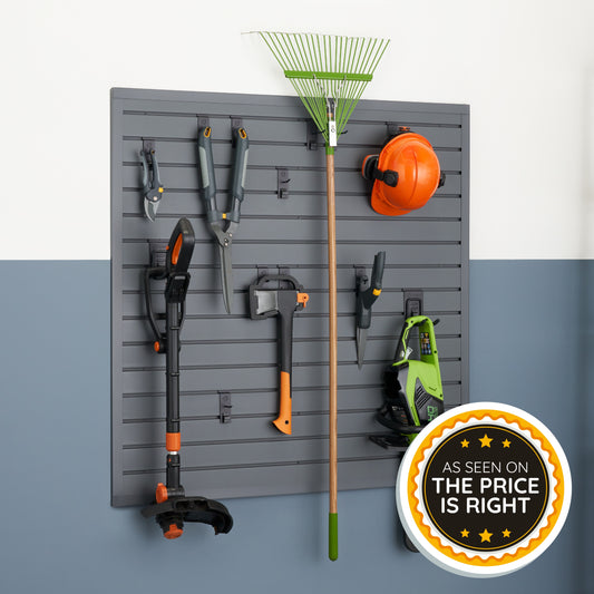 Various outdoor yard tools, including a leaf rake, hedge shears, and a string trimmer, are neatly organized on a grey slatwall storage panel mounted to a wall. A circular badge in the bottom right corner features yellow stars and the text "As Seen On The Price Is Right."