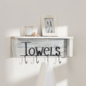 A rustic white wooden shelf with the word 