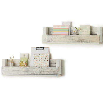 A set of two rustic wooden wall shelves in a distressed white finish, mounted on a white background. The shelves hold various stationery items, including notepads, a clipboard, books, and decorative elements.