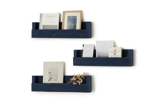 Here are three rustic reclaimed wood shelves mounted on a white wall, each holding a book and a framed picture. The shelves are dark blue and have a simple, minimalist design.