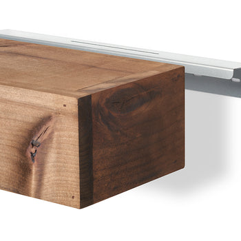 A solid, rustic wooden floating shelf is shown next to a sleek silver metal wall bracket. The wood features a natural grain and knots, while the bracket is designed to be hidden behind the shelf once installed.