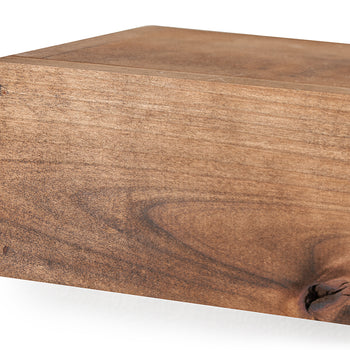A close-up shot focuses on the left corner of a rectangular, floating wooden shelf, highlighting its smooth surface and rich brown finish. The detailed view showcases the organic textures of the wood, including a distinct swirling grain and a prominent dark knot at the bottom right.