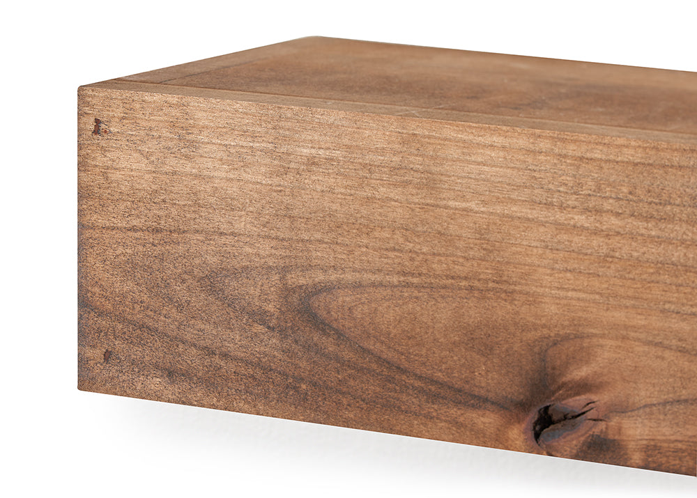 A close-up shot focuses on the left corner of a rectangular, floating wooden shelf, highlighting its smooth surface and rich brown finish. The detailed view showcases the organic textures of the wood, including a distinct swirling grain and a prominent dark knot at the bottom right.