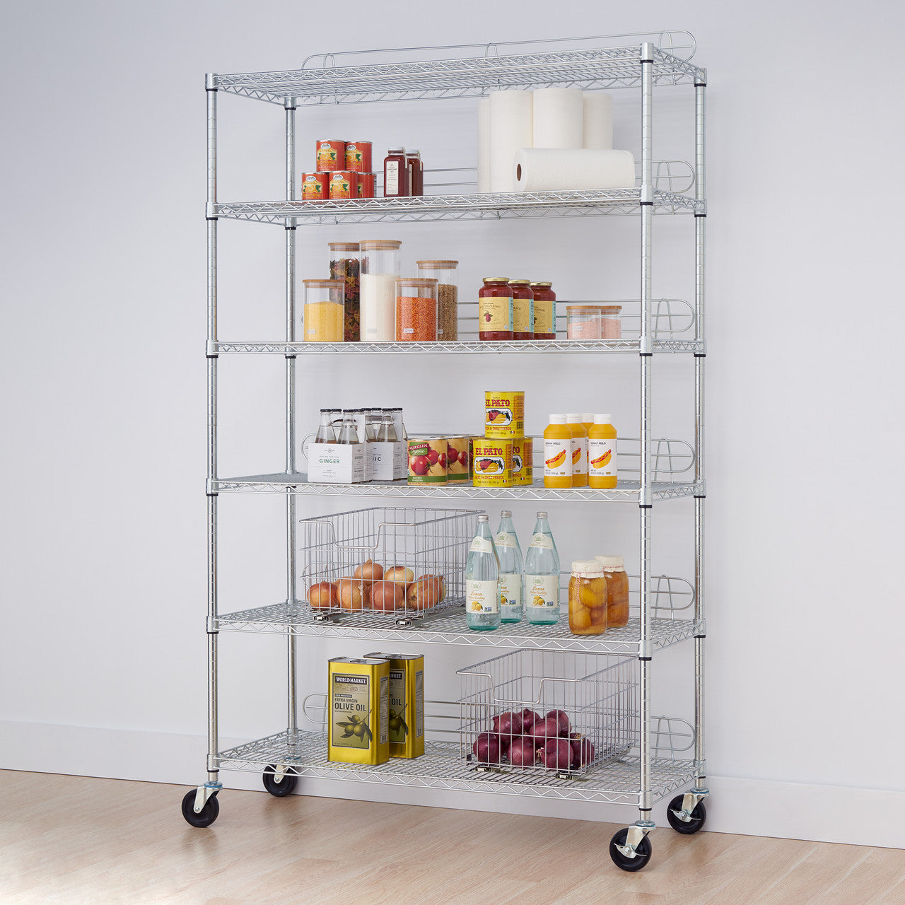 A six-tier chrome Trinity rolling steel wire shelving unit is filled with various pantry items. The shelves hold food storage containers, canned goods, bottles, and wire baskets filled with onions and other produce.
