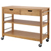 
A natural bamboo kitchen island on wheels features a solid wood top with two drawers. Below the drawers are two open shelves, and on one side, two metal bars extend for hanging storage.