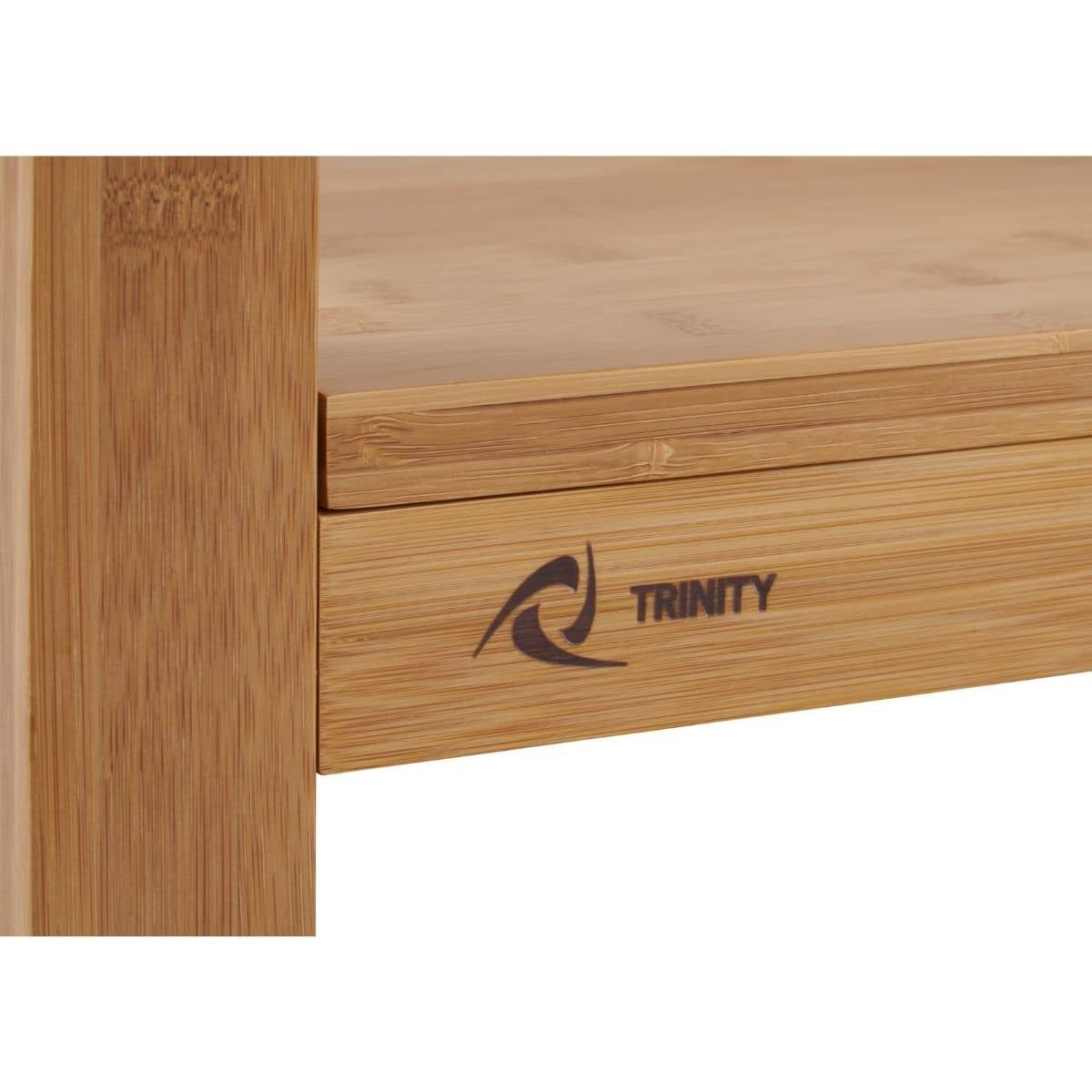 A close-up shows a portion of a bamboo kitchen island. The word "TRINITY" and a stylized wave-like logo are printed on the front of a drawer.