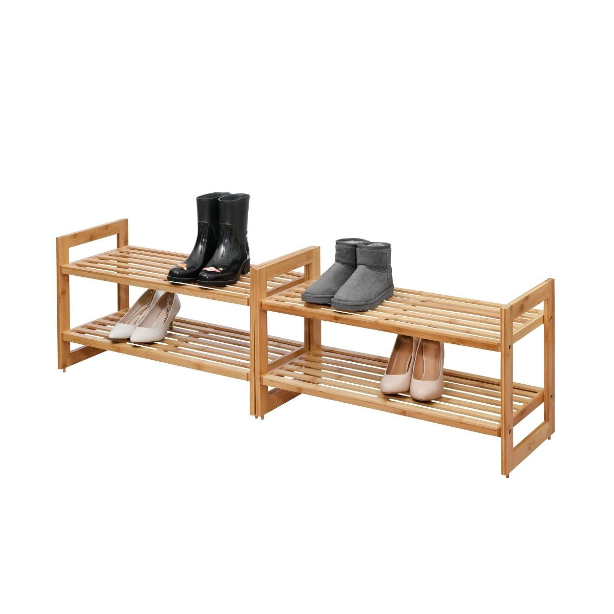 Two light brown, two-tiered bamboo shoe racks are positioned next to each other against a white background. The left rack holds a pair of black rain boots on the top shelf and two pairs of light-colored heels on the bottom, while the right rack displays a pair of gray ankle boots on top and two pairs of light-colored heels below.