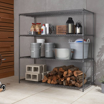 A four-tier wire shelving unit stands against a gray wall, holding various household and outdoor items. The shelves contain bags, bottles, buckets, lanterns, cinder blocks, and a pile of firewood.
