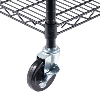 A close-up shot shows the bottom of a black wire shelving unit. A black wheel with a silver bracket is attached to one of the vertical poles of the shelf, and the 