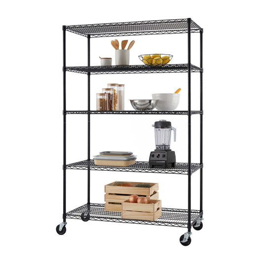 A tall black wire shelving unit on caster wheels holds kitchen essentials, including utensils, fruit, storage jars, bowls, a blender, and stacked dishes. Wooden crates with produce are stored on the bottom shelf, providing additional organized storage.