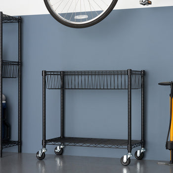 A black wire shelving unit with two tiers and wheels sits in the center of a garage against a dark blue wall, with a taller shelving unit to the left and a yellow bicycle pump to the right. A bicycle wheel hangs above.