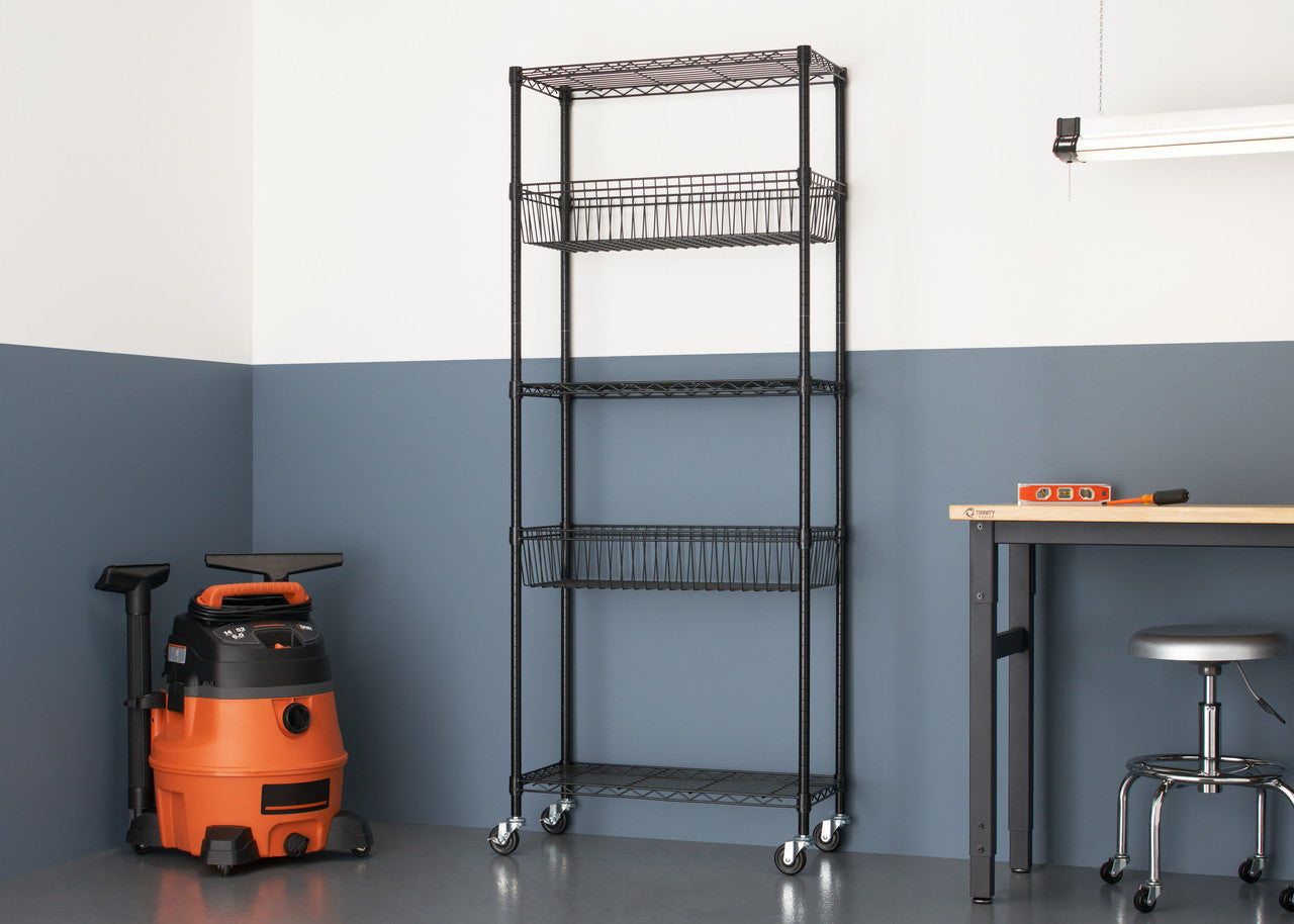 A black, five-tier wire shelving rack with wheels stands against a two-tone wall in a garage setting. The rack includes two wire baskets and is positioned near a vacuum cleaner and a workbench.