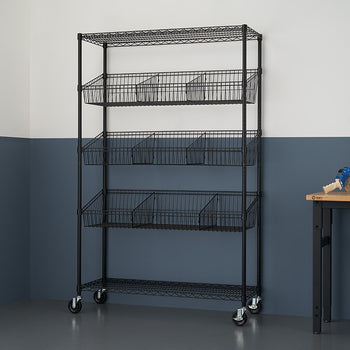 A black wire shelving unit with five tiers, some holding wire baskets, stands against a two-tone wall with a dark blue lower section. A wooden table and a metal stool are partially visible to the right.