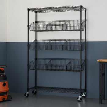 A black wire shelving unit with five tiers, each containing a wire basket and dividers, stands against a two-toned wall. The shelves are on wheels, and a wet/dry vacuum and a small table with a stool are visible in the background.