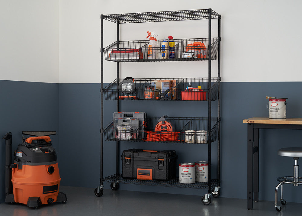 A black wire shelving unit with five tiers of baskets is filled with various tools and supplies in a garage setting. The unit is on wheels and stands against a two-toned wall, with a shop vac and a workbench visible in the background.