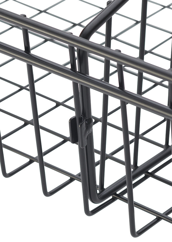 A close-up shot of a black wire basket corner, showing the grid pattern and a hinged latch. The basket's wires are thin and form a series of angled squares.