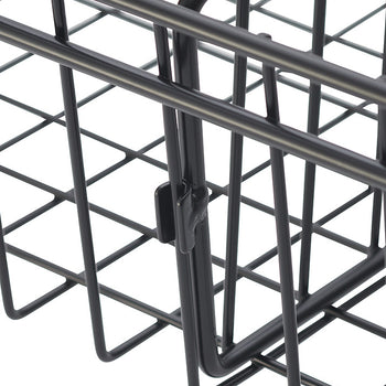 A close-up shot of a black wire basket corner, showing the grid pattern and a hinged latch. The basket's wires are thin and form a series of angled squares.